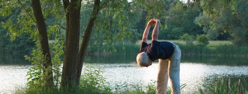 Senior man exercising next to a lake