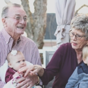 Grandmother and grandfather holding their grandchildren on their lap