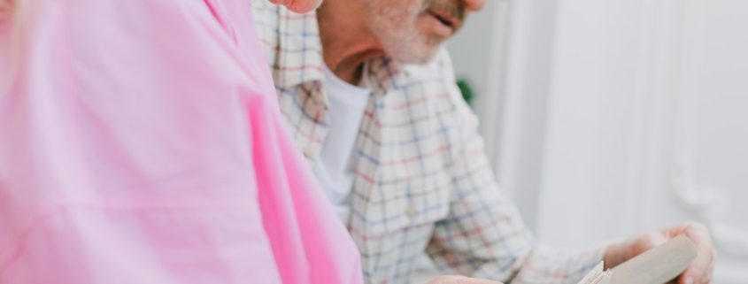 An elderly couple with gray hair looking at photos together