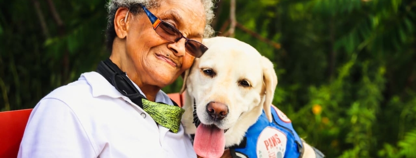 Elderly woman sitting beside a dog