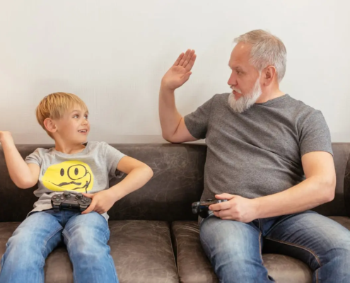 A grandfather and a boy playing console game