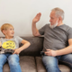 A grandfather and a boy playing console game